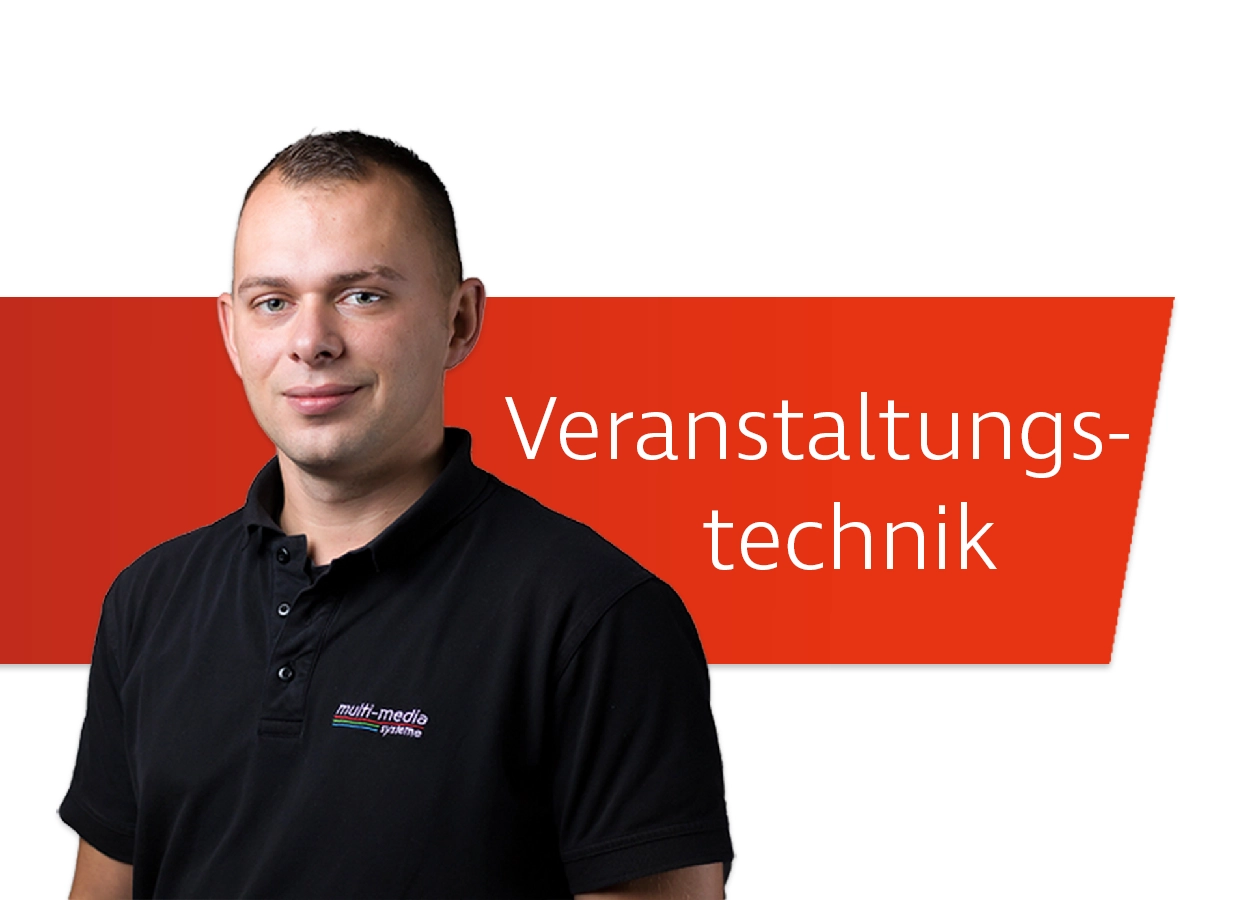 Mitarbeiter der Veranstaltungstechnik posiert vor dem Schriftzug "Veranstaltungstechnik"