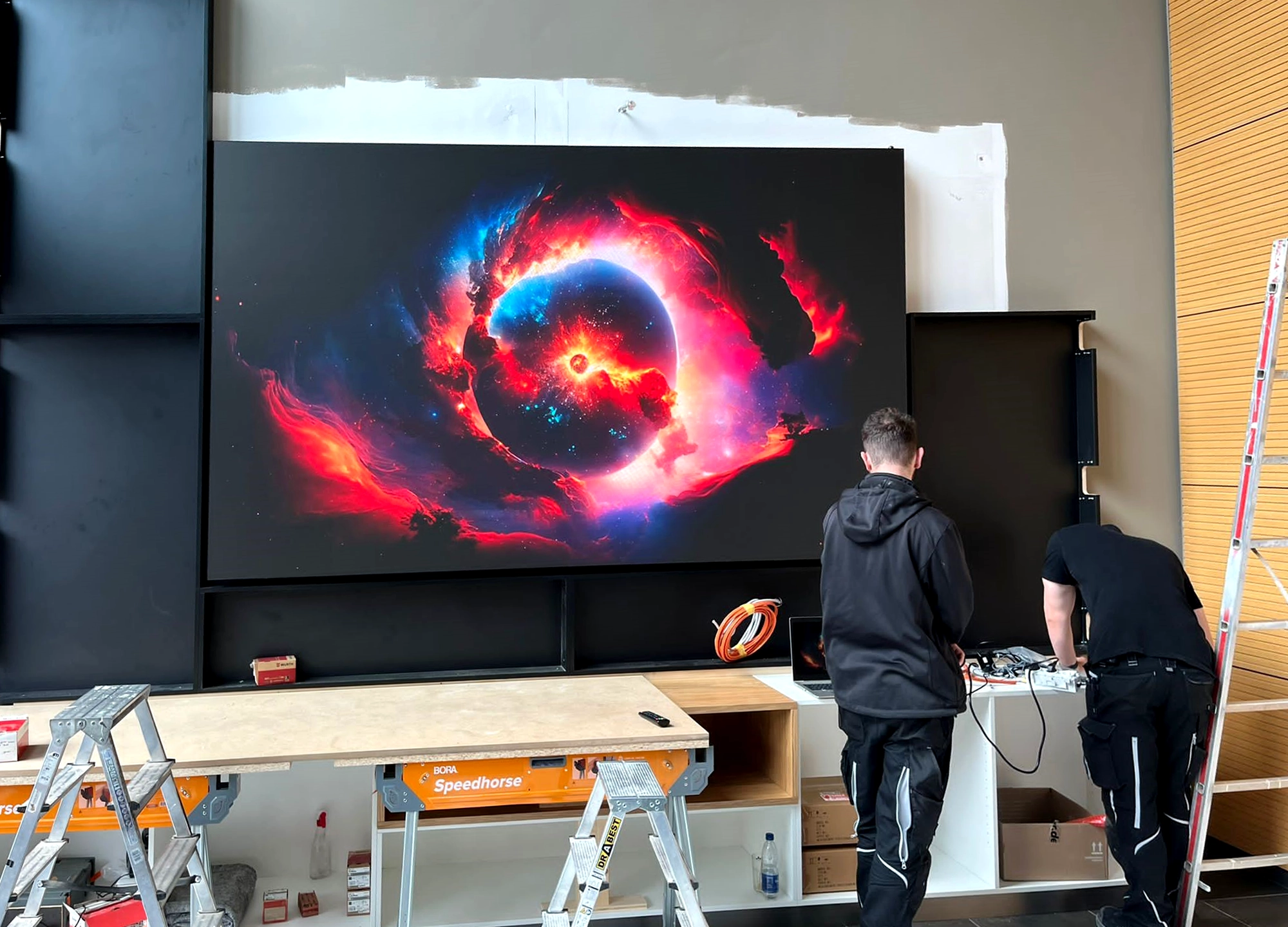 Techniker installieren die LED-Wand im Empfangsbereich der Admedes GmbH