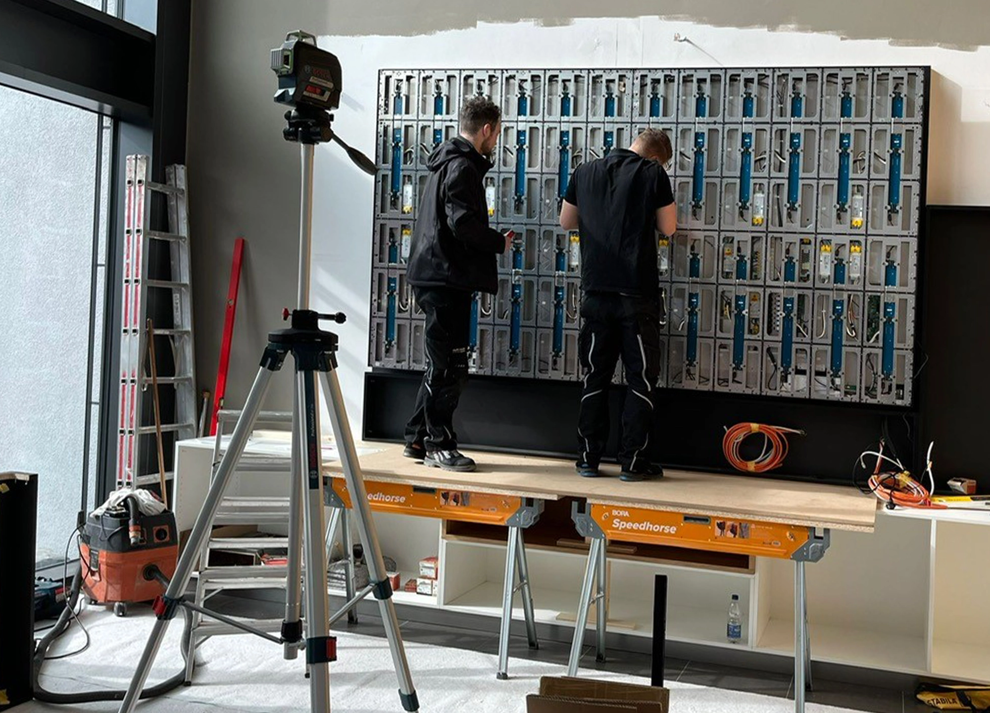 Techniker installieren die LED-Wand im Empfangsbereich der Admedes GmbH